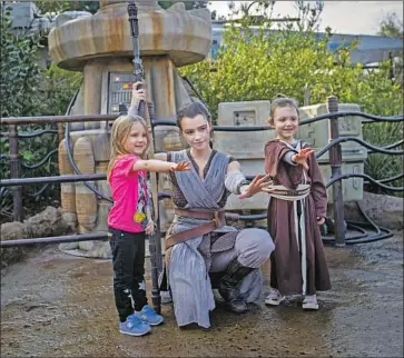  ?? Allen J. Schaben Los Angeles Times ?? A CAST member dressed as Rey pauses with Penny, 4, left, and Adelaide Remaklus, 7, at the park in January.