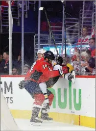  ?? AP/NICK WASS ?? Washington Capitals defenseman Brooks Orpik (left) checks Pittsburgh Penguins right wing Patric Hornqvist into the boards during the Capitals’ 4-1 victory over the Pittsburgh Penguins on Sunday in Washington, D.C. The best-of-seven series is tied 1-1.