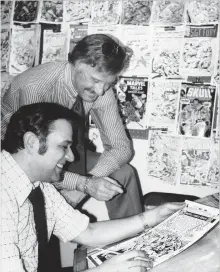  ?? THE ASSOCIATED PRESS ?? Jan. 10, 1976: Stan Lee, standing, publisher of Marvel Comics, discusses a “Spiderman” comic book cover with artist John Romita.