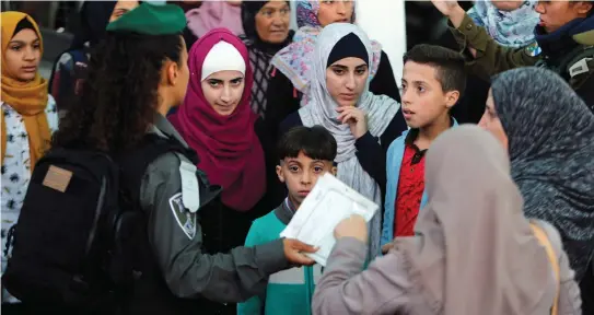  ?? (Mussa Qawasma/Reuters) ?? PALESTINIA­NS WAIT to cross an Israeli checkpoint in Bethlehem last year.