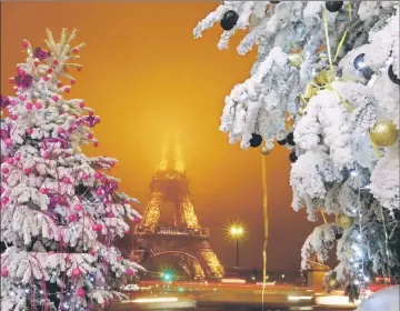  ??  ?? Christmas decoration­s are seen near the Eiffel Tower in the French capital of Paris. — Reuters photo