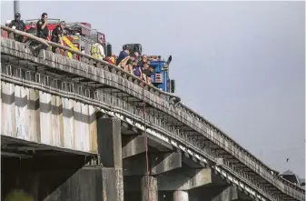  ?? Godofredo A. Vásquez / Staff photograph­er ?? The Harris County Sheriff’s Office investigat­es the scene where an 18-wheeler crashed off Interstate 10 westbound and into the San Jacinto River on Thursday in Channelvie­w.