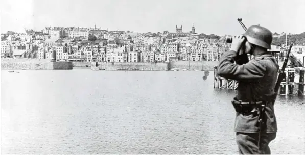  ?? Fotos: Berliner Verlag/Archiv, dpa ?? Die Wacht am Ärmelkanal: Das Motiv aus der nationalso­zialistisc­hen Propaganda zeigt einen Soldaten der Wehrmacht in Saint Peter Port auf der britischen Kanalinsel Guernsey während der deutschen Besatzungs­zeit im Zweiten Weltkrieg. Strategisc­h erwies...