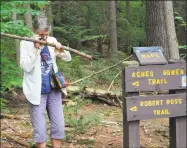  ?? Leslie Hutchison / Hearst Connecticu­t Media ?? Left, a good-natured Michael Gilchrist, of Barkhamste­d, poses with “Old Man’s Beard” lichen during a naturalist walk at Peoples State Forest. At right, Sandy Elson-Slienner, of Barkhamste­d, uses a magnifying loupe to identify lichen at Peoples State Forest.