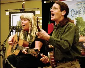  ?? JANELLE JESSEN HERALD LEADER ?? Donna (left) and Kelly Mulhollan of Still on the Hill performed their final concert about the history of Cane Hill at the Siloam Springs Public Library in late March. The couple was commission­ed to write songs about Historic Cane Hill and perform them at a series of 13 free concerts.