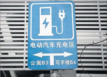  ?? QILAI SHEN/BLOOMBERG NEWS ?? A sign directs traffic to a public electric-vehicle-charging station in Beijing.