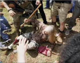  ?? THE ASSOCIATED PRESS ?? A man falls after being hit by counter demonstrat­ors during a protest, Aug. 15, in Stone Mountain Village, Ga.