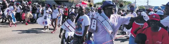  ?? PHOTOS: ANDREA SACHS/THE WASHINGTON POST ?? A Second Line parade with a brass band, floats and coolers filled with beer makes its way through the Uptown neighbourh­ood of New Orleans.