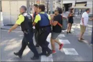  ??  ?? An injured person is carried in Barcelona, Spain, Thursday.