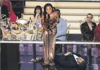  ?? Myung J. Chun Los Angeles Times ?? “ABBOTT ELEMENTARY’S” Quinta Brunson gamely accepts her Emmy for comedy writing on Monday as presenter Jimmy Kimmel plays dead. The late-night TV host’s bit drew some backlash online.
