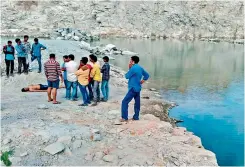  ??  ?? Youths wait with the body of their friend, who was one of the two persons who drowned during a picnic near Ghatkesar on Thursday.