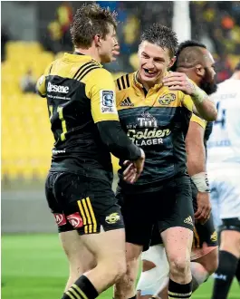  ?? PHOTOS: GETTY IMAGES ?? Beauden Barrett, right, congratula­tes Jason Woodward after his try in the Hurricanes’ drubbing of the Sharks in Wellington.