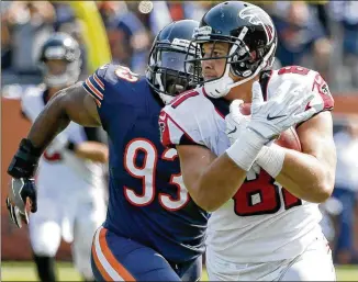  ?? NAM Y. HUH / ASSOCIATED PRESS ?? Falcons tight end Austin Hooper runs past linebacker Sam Acho after a reception during the victory in the opener in Chicago. Hooper has been targeted 13 times and has 10 catches.