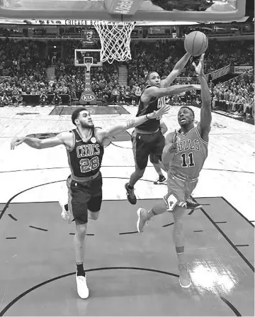  ?? — AFP photo ?? David Nwaba #11 of the Chicago Bulls drives to the basket against Abdel Nader #28 and Al Horford #42 of the Boston Celtics at the United Center on December 11, 2017 in Chicago, Illinois.