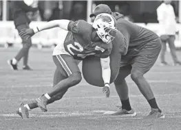  ?? ?? Kaiir Elam fights off a block during punt blocking drills.