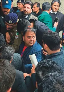  ?? AFP ?? Police officials escort the arrested leader of opposition Pakistan Tehreek-e-Insaf party, Fawad Chaudhry (centre) to present him before a court in Lahore yesterday.