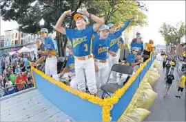  ?? Gene J. Puskar Associated Press ?? PLAYERS FROM Rancho Santa Margarita, representi­ng the West region, ride in the Little League Grand Slam Parade ahead of the World Series.