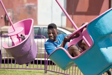  ?? Staff photos by Joshua Boucher ?? Tamareon Kelly, 12, spins on a ride Saturday at the RailFest event in downtown Texarkana. While the ride spins, riders can also turn the wheel to make the carriage spin on an additional axis.