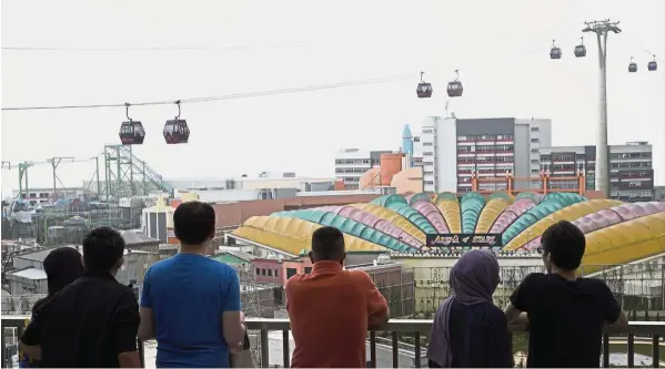  ?? — AP ?? No walk in the park:A file picture showing visitors at one of the attraction­s in Genting Highland Resort. Genting Malaysia is claiming more than US$1bil from 21st Century Fox Inc and Walt Disney Co for pulling out of a theme park deal.