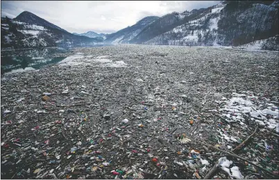  ??  ?? Plastic bottles and other garbage floats in the Potpecko lake near Priboj, in southwest Serbia on Jan. 22. A United Nations report released says humans are making Earth a broken and increasing­ly unlivable planet through climate change, biodiversi­ty loss and pollution. So the world must make dramatic changes to society, economics and daily life. (File Photo/AP/Darko Vojinovic)