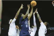  ?? JIMMIE MITCHELL/SBC PHOTOS ?? Old Dominion’s Tyrone Williams puts up a shot as he’s surrounded by three Texas State defenders during Tuesday night’s Sun Belt Tournament game in Pensacola, Florida. Williams finished with a career-high 36 points.