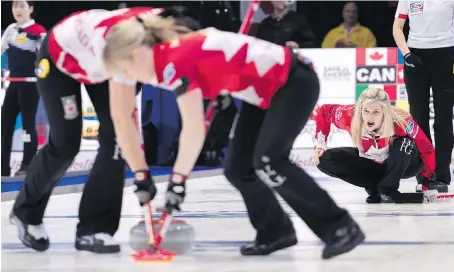  ?? PAUL CHIASSON/THE CANADIAN PRESS ?? Canada skip Jennifer Jones watches her rock being swept by lead Dawn McEwen, right, and second Jill Officer as they face Italy at the World Women’s Curling Championsh­ip Thursday in North Bay. Her rink swept through the round robin to the semifinal.