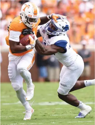  ?? STAFF PHOTO BY ROBIN RUDD ?? Tennessee starting running back John Kelly tries to shake loose of Indiana State’s Jonas Griffith during Saturday’s game at Neyland Stadium. Kelly totaled 80 yards on the ground and had 60 more on catches in the win.