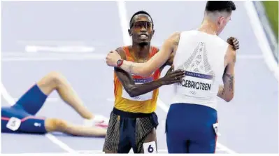  ?? Efe / Julio Muñoz ?? Thierry Ndikumwena­yo felicita al noruego Jakob Ingebrigts­en, que se proclamó campeón en los 5.000.