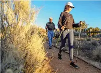  ?? GABRIELA CAMPOS/THE NEW MEXICAN ?? Bella Marquez, 12, and her grandfathe­r, Bo Howard, hike down the Camino Cruz Blanca Trail on Wednesday while visiting Santa Fe for Thanksgivi­ng. As the #OptOutside movement grows, people are urged to get outdoors this holiday weekend. To encourage New...