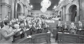  ??  ?? Le président catalan Carles Puigdemont et les députés applaudiss­ent après le vote de la résolution
