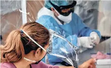  ?? /EFE ?? Empleados de salud realizan pruebas de COVID-19, en la Central de Abastos de Ciudad de México.