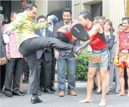  ??  ?? Prime Minister Prayut Chan-o-cha, left, demonstrat­es his Muay Thai skills during a promotiona­l event earlier this year.