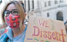  ?? MARY ALTAFFER/AP ?? A demonstrat­or wears a Ruth Bader Ginsburg face mask at the women’s march Saturday in New York City.