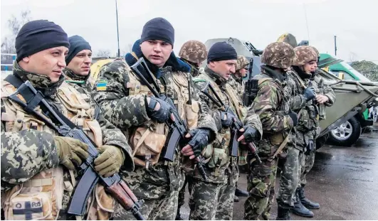  ?? SERGEY BOBOK/ AFP/ GETTY IMAGES ?? Ukrainian bor der guards line up before starting their pa trol on the Rus sian bor der, in the vil lage of Veseloye, in the Khar kiv re gion last Fri day.