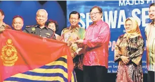  ??  ?? TAHNIAH: Abang Johari menyampaik­an trofi kepada Ketua Zon Jabatan Bomba dan Penyelamat Zon 6 Sarawak Law Poh Kiong mewakili pasukannya dipilih sebagai pemenang Tapak Pameran Terbaik Sejiwa Senada di Miri malam kelmarin.