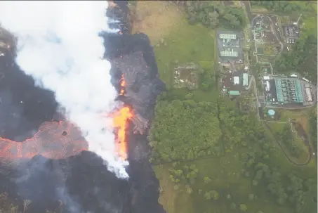  ?? Mario Tama / Getty Images ?? Lava erupts and flows from a Kilauea volcano fissure, near the Puna geothermal plant (top right) on Hawaii’s Big Island.