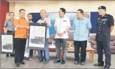  ??  ?? Salang (fourth right) presents a land certificat­e to TR Genta Sabot at the function while others look on.