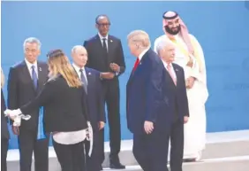  ?? AP PHOTO/PABLO MARTINEZ MONSIVAIS ?? President Donald Trump arrives and joins other heads of state for a family photo at the G20 summit Friday in Buenos Aires, Argentina. From left in the front row are Singapore Prime Minister Lee Hsien Loong, Russian President Vladimir Putin and Brazil President Michel Temer. From left on the top row are Rwanda President Paul Kagame and Saudi Arabia’s crown prince Mohammed bin Salman.