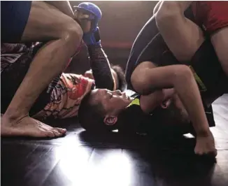  ?? PHOTOS FRED DUFOUR AGENCE FRANCE-PRESSE ?? De jeunes garçons combattent durant un entraîneme­nt au Enbo Fight Club.