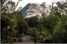  ??  ?? People look up at Mount Merapi, Indonesia’s most active volcano, as it spews rocks and ash out for another day in Yogyakarta. Photograph: Agung Supriyanto/AFP/ Getty Images