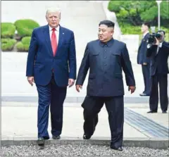  ?? BRENDAN SMIALOWSKI/AFP ?? In a historic first, North Korea’s Kim Jong-un and US President Donald Trump cross the Military Demarcatio­n Line that divides North and South Korea on Sunday.