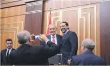  ?? Reuters ?? Finance Minister Ali Khalil takes a photograph of Speaker Nabih Berri with Prime Minister Saad Hariri in parliament