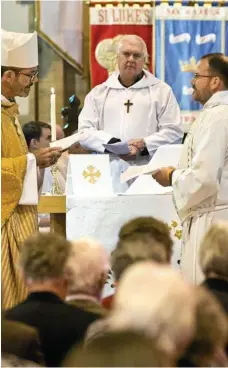  ?? PHOTO: NEV MADSEN ?? PAUL’S PARISH: Father Paul Mitchell (right) is commission­ed as Priest In Charge of St Luke’s Parish by Bishop Cameron Venables (left) and liturgical assistant Paul Smith (centre).