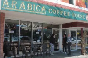  ?? KRISTI GARABRANDT —THE NEWS-HERALD ?? Arabica employee Michelle Wank tells longtime customers Jo and Scott Farnham that Arabica has permanentl­y closed when they arrived for coffee on Oct. 16.