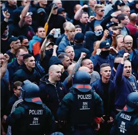  ?? (ODD ANDERSEN/AFP PHOTO) ?? Des policiers allemands tentent de tenir en respect des manifestan­ts d’extrême droite à Chemnitz, dans l’ex-Allemagne de l’Est.