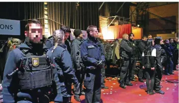  ?? FOTO: BRANDON LEE POSSE ?? Polizisten sichern in der Nacht auf Sonntag die Garderobe in der Saarbrücke­r Eventhalle E-Werk. Dort war es vorher zu Tumulten gekommen, als Besucher ihre Jacken und Mäntel nicht zurückbeka­men.