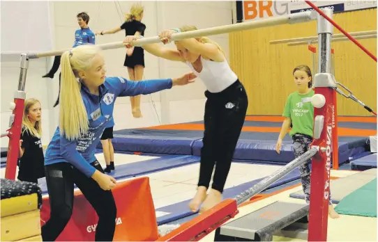  ??  ?? SVINGSTANG: Cathrine Gusdal (10) og Natalie Larsen (9) får god hjelp av Aurora Lauritzen Andresen i svingstang­a.