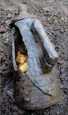  ?? FOTO: REUTERS/NTB SCANPIX ?? I en sprekk kom tilsynelat­ende blankpusse­de gullmynter til syne. Den yngste av dem er fra midten av 400-tallet.