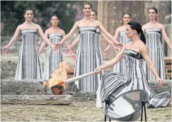  ?? AFP ?? Greek actress Mary Mina, playing the role of the High Priestess, lights the torch during the flame lighting ceremony for the Paris 2024 Olympics Games at the ancient temple of Hera on the Olympia archaeolog­ical site in southern Greece.