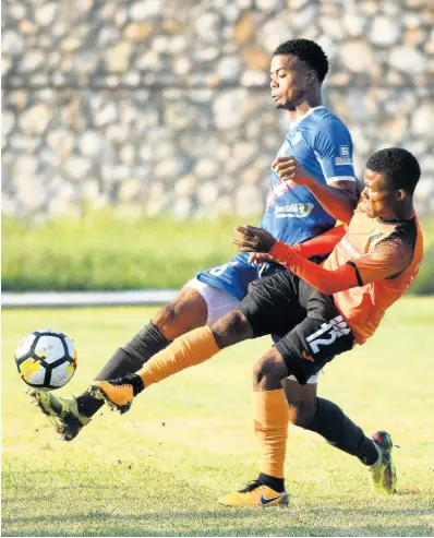  ?? FILE ?? Portmore United’s Romaine Breakenrid­ge (left) makes a clearance while under pressure from Tivoli Garden’s Howard Morris during a Red Stripe Premier League encounter at the Spanish Town Prison Oval.